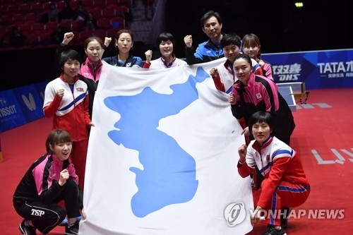 In this EPA photo from May 4, 2018, members of the unified Korean women's table tennis team hold up the Korean Unification Flag after losing to Japan in the semifinals of the World Team Table Tennis Championships at Halmstad Arena in Halmstad, Sweden. (Yonhap)