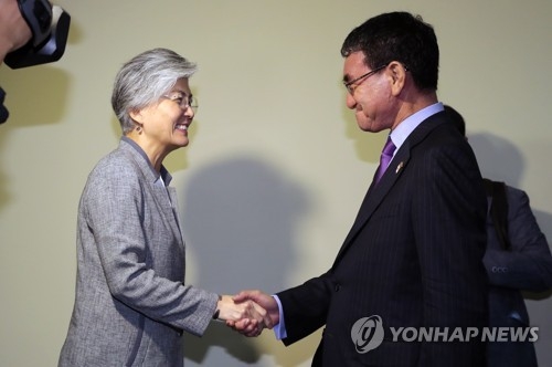 South Korea's Foreign Minister Kang Kyung-wha (L) shakes hands with her Japanese counterpart Taro Kono in Singapore talks on Aug. 2, 2018. (Yonhap)