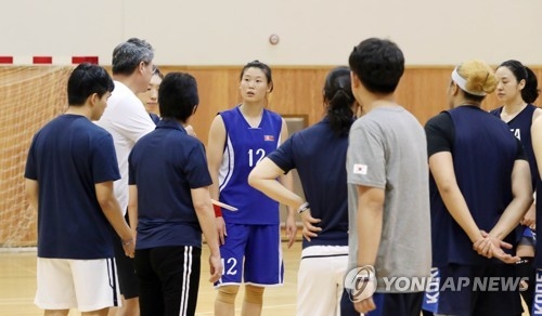 Members of the joint Korean women's basketball team huddle around head coach Lee Moon-kyu (L, in white shirt) during practice at the Jincheon National Training Center in Jincheon, 90 kilometers south of Seoul, on Aug. 2, 2018. The two Koreas will compete as one team at the 2018 Asian Games in Jakarta and Palembang, Indonesia. (Yonhap)