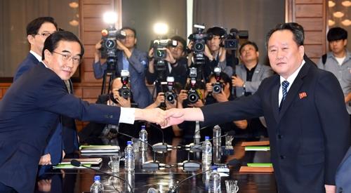 This photo taken by joint press corps shows South Korea's Unification Minister Cho Myoung-gyon (L) shake hands with his North Korean counterpart Ri Son-gwon before launching high-level talks on Aug. 13, 2018 on the northern side of Panmunjom to discuss inter-Korean relations and preparations for a summit meeting between their leaders. (Yonhap)