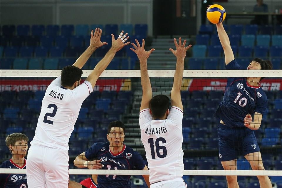 In this photo provided by FIVB on Jan. 11, 2020, Jung Ji-seok of South Korea (R) hits a spike against Milad Ebadipour (L) and Ali Shafiei of Iran during the teams' semifinals match at the Asian Olympic men's volleyball qualification tournament at Jiangmen Sports Center Gymnasium in Jiangmen, China. (PHOTO NOT FOR SALE) (Yonhap)
