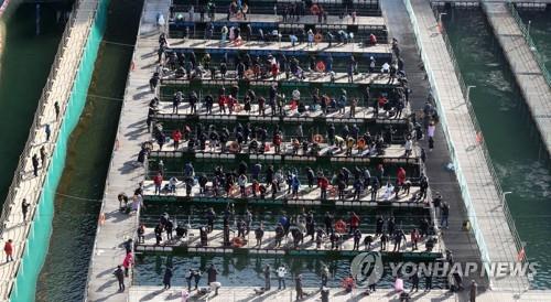 This photo provided by Hwacheon County Office shows tourists enjoying river fishing in Hwacheon, northeast of Seoul, during the 2020 Hwacheon Sancheoneo Ice Festival. (PHOTO NOT FOR SALE) (Yonhap)