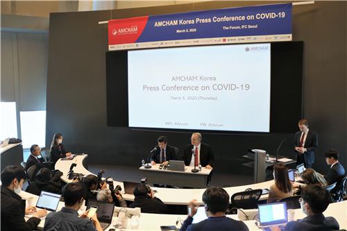 This photo taken on March 5, 2020, and provided by the American Chamber of Commerce in Korea (AMCHAM) shows AMCHAM Chairman & CEO James Kim (L) and Jeffrey Jones, chairman of the AMCHAM Board of Governors, delivering a briefing on AMCHAM member firms' stance toward the South Korean government's reaction to the spreading coronavirus outbreak at a press conference at the International Finance Corporation mall in Yeouido, Seoul. (PHOTO NOT FOR SALE) (Yonhap) 