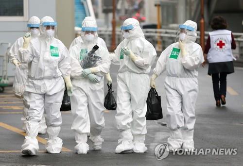 Medical professionals wearing protective gear are seen walking into a hospital in South Korea's southeastern city of Daegu on March 27, 2020. (Yonhap)