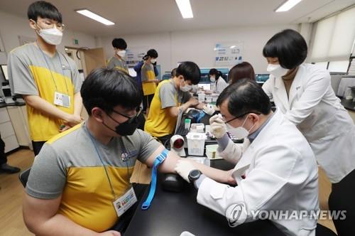 Aspiring soldiers wearing masks have their blood taken during a medical checkup at the Seoul office of the Military Manpower Administration on Feb. 3, 2020, part of the year's first batch of applicants evaluated by the office. (Yonhap)