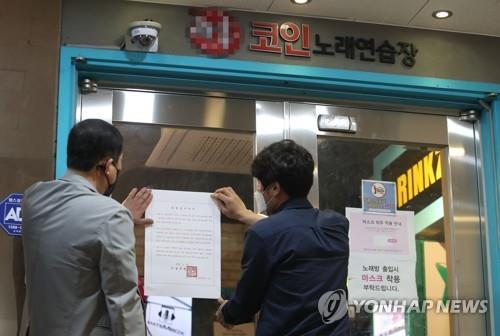 Seoul city officials put a notice of business suspension on the entrance of a "coin noraebang," a coin-operated karaoke room, in Seoul on May 22, 2020. (Yonhap)