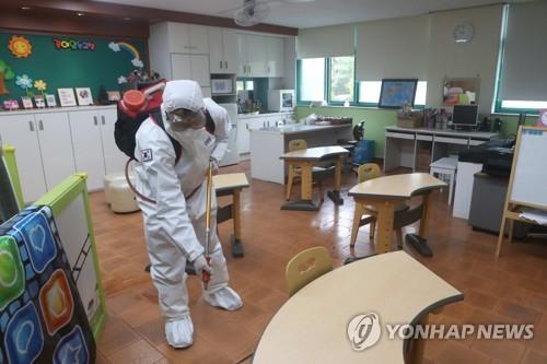 A military medical official disinfects a classroom at an elementary school in Paju, north of Seoul, on May 25, 2020. (Yonhap)