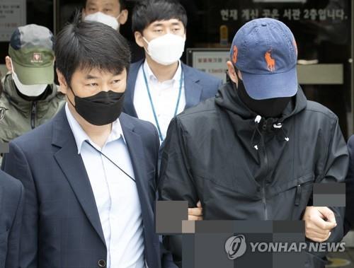 Two paid members (wearing both masks and caps) of the "Baksabang" chatroom on the messaging service Telegram leave the Seoul Central District Court on May 25, 2020, after attending their arrest warrant hearing. (Yonhap)