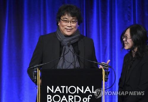 In this photo released by the Associated Press, South Korean director Bong Joon-ho (L) speaks at the National Board of Review Awards gala in New York for winning the best foreign language film for "Parasite" on Jan. 8, 2020. His interpreter Sharon Choi stands next to him. (Yonhap)