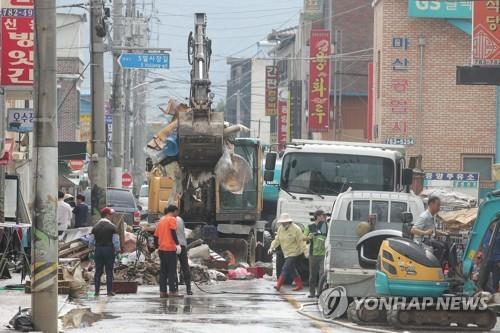 Work to restore a flood-damaged traditional market is under way in Gurye, South Jeolla Province, on Aug. 11, 2020. The entire county was inundated by heavy rains. (Yonhap)