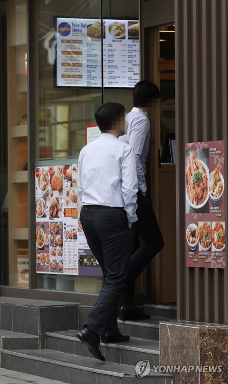 Office workers enter a restaurant during lunch time in Seoul on Sept. 14, 2020, the first day of the easing of toughened social distancing guidelines, as the number of new COVID-19 cases noticeably declined. Over the past two weeks, only takeout was available at cafes, while restaurants could only serve takeout and delivery after 9 p.m. amid the spreading virus. (Yonhap)