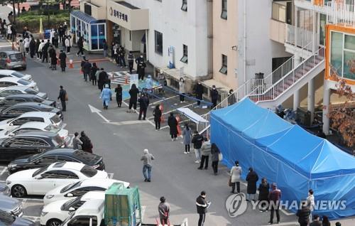 Citizens wait in line to receive COVID-19 tests at a makeshift virus testing clinic in Seoul on Nov. 25, 2020. (Yonhap)