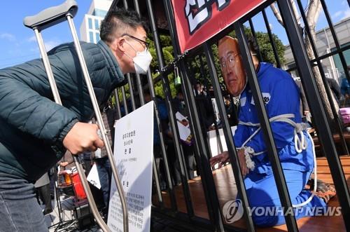 A civic activist carries out a performance in front of the Gwangju District Court to demand former President Chun Doo-hwan be punished on Nov. 30, 2020. (Yonhap) 