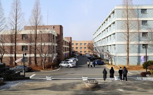 Students walk near a dormitory building at Ajou Motor College in Boryeong, central South Korea, on Dec. 16, 2020, after a coronavirus cluster infection there. (Yonhap)