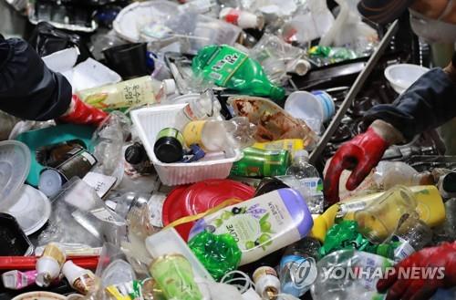 Workers sort plastic waste at a recycling center in Busan, 453 km southeast of Seoul, on Dec. 24, 2020. (Yonhap)