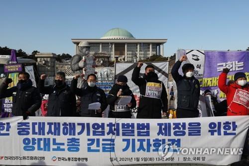 Officials from umbrella labor unions hold a press conference in front of the National Assembly in Seoul on Jan. 5, 2021, calling for the parliamentary passage of legislation on punishing companies for severe workplace disasters. (Yonhap) 