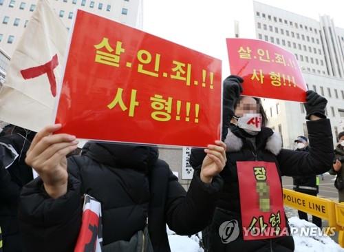 Protesters hold signs demanding the death sentence for the adoptive mother of Jung-in outside Seoul Southern District Court on Jan. 13, 2021. (Yonhap)