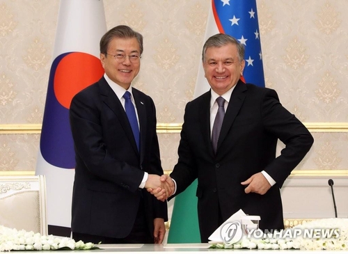 South Korean President Moon Jae-in (L) shakes hands with his Uzbek counterpart, Shavkat Mirziyoyev, during their summit talks in Tashkent in this file photo taken on April 19, 2019. (Yonhap)