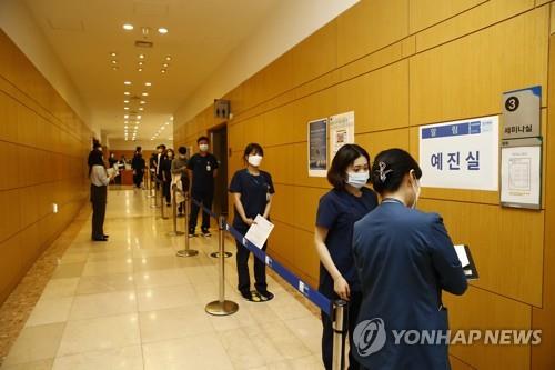 Medical workers wait in line for a vaccine shot on March 11, 2021, in this photo provided by NHIS Ilsan Hospital. (PHOTO NOT FOR SALE) (Yonhap)