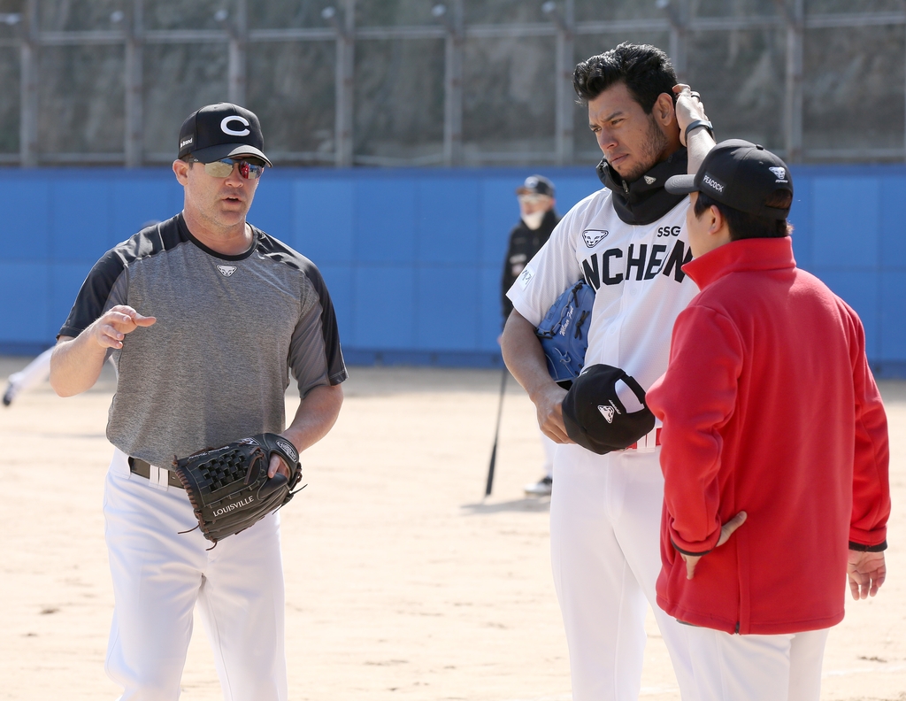 SSG Landers coach Brandon Knight (L) works with pitcher Wilmer Font (C) during practice in Busan, 450 kilometers southeast of Seoul, on March 9, 2021, in this photo provided by the Landers. (PHOTO NOT FOR SALE) (Yonhap)