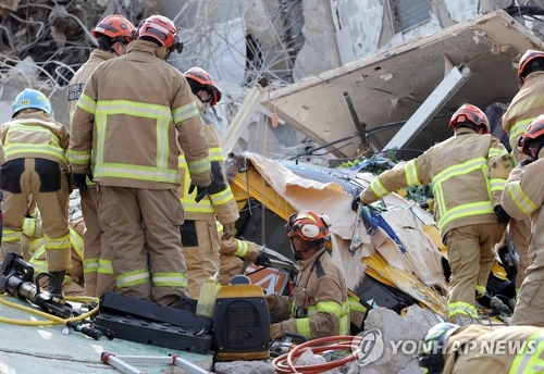 Firefighters rescue people trapped under a mound of debris in the southwestern city of Gwangju on June 9, 2021. (Yonhap)