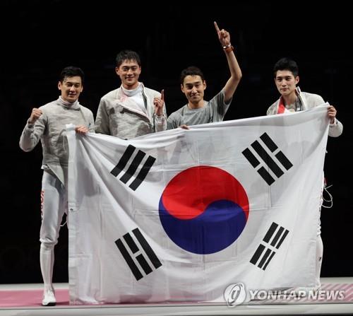 South Korean fencers -- (from L to R) Gu Bon-gil, Oh Sang-uk, Kim Jung-hwan and Kim Jun-ho -- pose with the South Korean flag after winning the final of the men's team sabre fencing event over Italy at the Tokyo Olympics at Makuhari Messe Hall in Chiba, Japan, on July 28, 2021. (Yonhap)