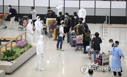 South Korean residents and diplomats from India are guided by quarantine officials upon arrival at Incheon International Airport, west of Seoul, on July 13, 2021, amid the fourth wave of COVID-19. (Yonhap)