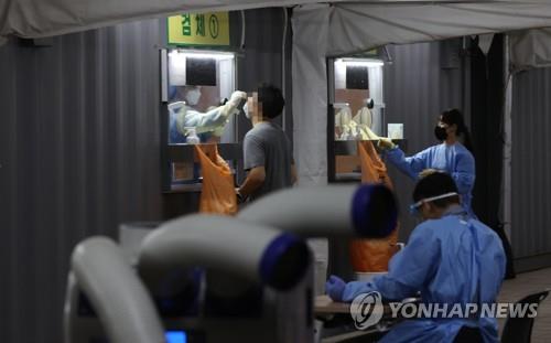 A person takes a virus test at a screening center set up at Seoul Plaza in downtown Seoul on Aug. 11, 2021, when daily confirmed cases surpassed 2,000 for the first time since the outbreak of the infections on Jan. 20, 2020. (Yonhap) 