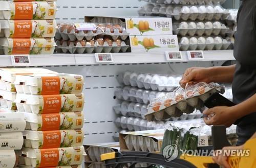 This file photo shows a shopper selecting eggs at a discount store in Seoul. (Yonhap)
