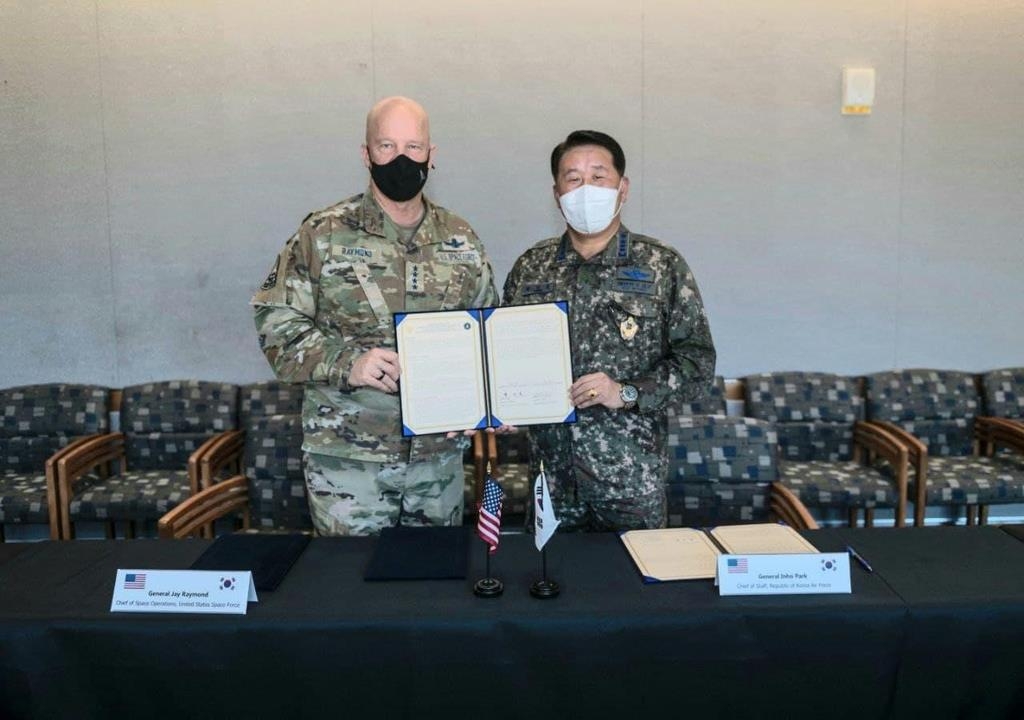 Air Force Chief of Staff Gen. Park In-ho (R) and U.S. chief of space operations, Gen. John Raymond, sign a memorandum of understanding on forming a joint space policy consultative body at the Air Force Space Command in Colorado, U.S., on Aug. 27, 2021 (local time), in this photo provided by South Korea's Air Force on Aug. 29, 2021.(PHOTO NOT FOR SALE) (Yonhap)