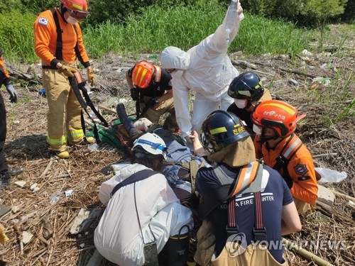 This photo provided by the city government of Goyang shows rescue workers preparing to airlift a man who was injured in a land mine explosion at Janghang Wetland in the city, northwest of Seoul, on June 4, 2021. (PHOTO NOT FOR SALE) (Yonhap)