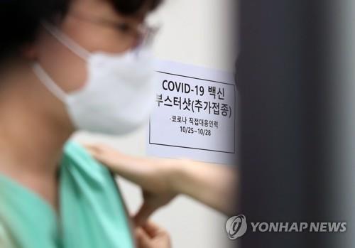A health worker at Seoul National University Hospital is given a COVID-19 booster shot on Oct. 25, 2021. (Yonhap) 