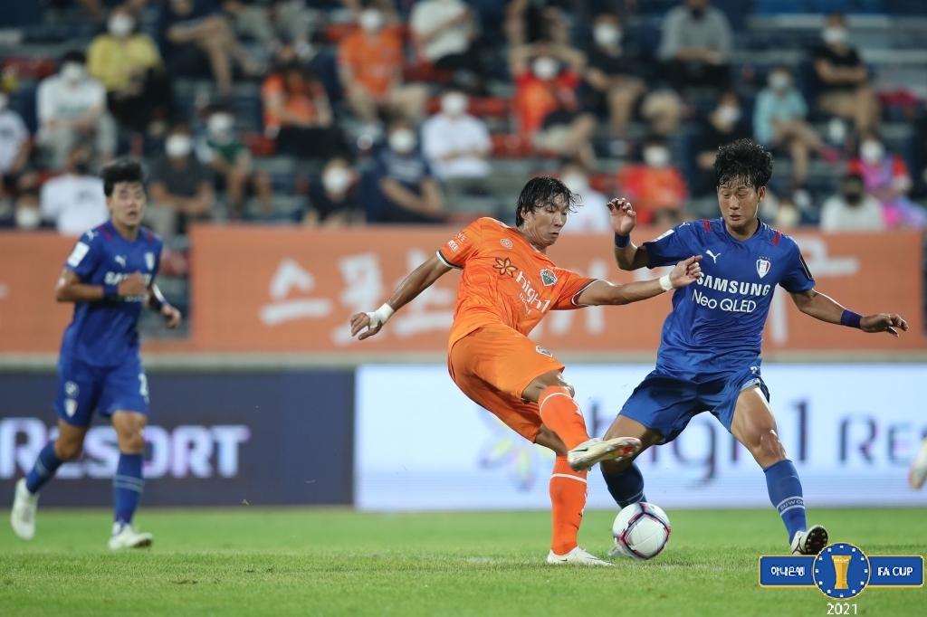 In this Aug. 11, 2021, file photo provided by the Korea Football Association, Go Moo-yeol of Gangwon FC (C) and Choi Jeong-won of Suwon Samsung Bluewings (R) battle for the ball during their clubs' quarterfinal match at the FA Cup at Songam Sports Town in Chuncheon, about 85 kilometers east of Seoul. (PHOTO NOT FOR SALE) (Yonhap)