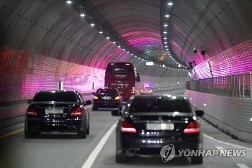 A bus and cars carrying government officials run through the Boryeong Undersea Tunnel, central South Korea, during a test drive on Nov. 30, 2021. (Yonhap)
