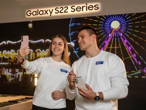 This photo, provided by Samsung Electronics Co. on Feb. 27, 2022, shows models posing with Galaxy S22 smartphones at the Mobile World Congress (MWC) 2022. (PHOTO NOT FOR SALE) (Yonhap)