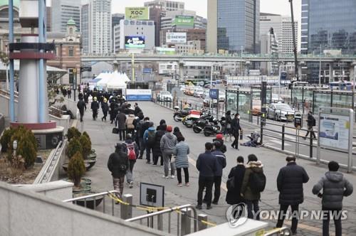A long line is formed with people waiting for their turn to get tested for the coronavirus in front of a testing center at Seoul Station on March 8, 2022. (Yonhap)