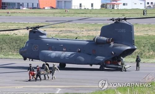 A helicopter crewman is moved from a just landed Air Force chopper to a hospital in Jeju after sustaining injuries in a crash of a Coast Guard helicopter in waters off South Korea's southernmost island of Mara on April 8, 2022. (Yonhap) 