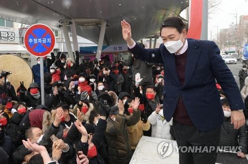 In this file photo, Yoon Suk-yeol, then the presidential candidate of the People Power Party, greets supporters at a market in the southwestern city of Gwangju on Feb. 16, 2022. (Pool photo) (Yonhap)