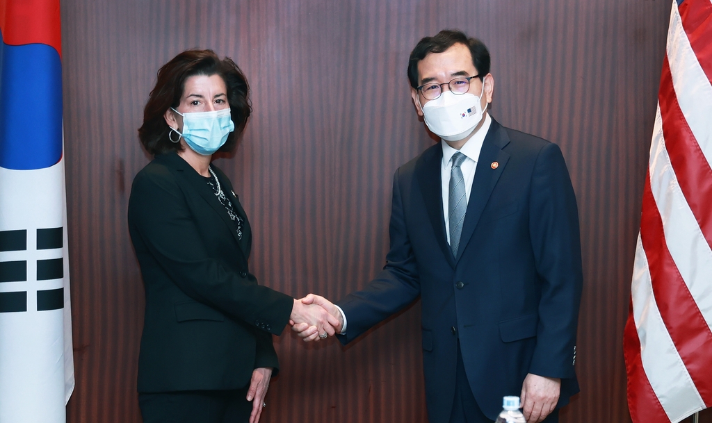 This photo, provided by South Korea's industry ministry, shows Industry Minister Lee Chang-yang (R) shaking hands with U.S. Commerce Secretary Gina Raimondo ahead of their meeting in Seoul on May 21, 2022. (PHOTO NOT FOR SALE) (Yonhap)