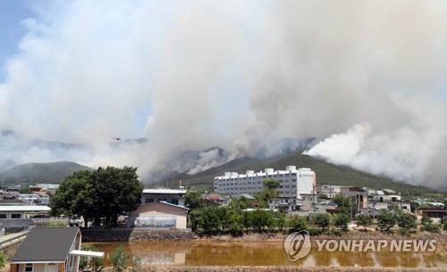 A wildfire is spreading near a village in Miryang, around 280 km southeast of Seoul, on May 31, 2022. (Yonhap)