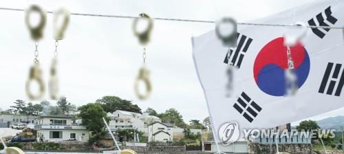 Replica handcuffs are hung during a rally in front of former President Moon Jae-in's residence in Yangsan, southeastern South Korea, in this file photo taken June 8, 2022. (Yonhap)