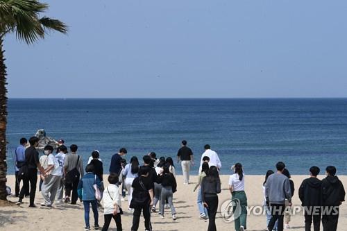 A group of students visits a beach in Gangwon Province on May 3, 2022, after the government eased social distancing rules and lifted an outdoor mask mandate. (Yonhap)