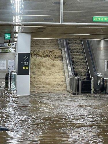 This photo provided by a news reader on Aug. 9, 2022, shows a cascade of rainwater flooding a subway station in Seoul. (PHOTO NOT FOR SALE) (Yonhap)