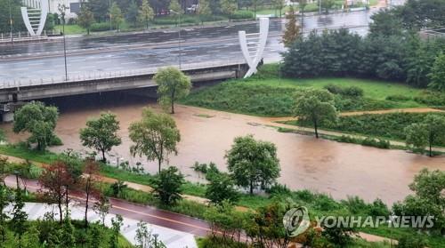 A walking trail along the Jinjam Stream in western Daejeon is submerged on Aug. 10, 2022, after heavy rainfall in the area. (Yonhap)