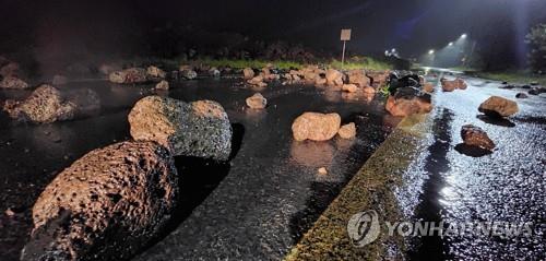 Rocks are strewn across a seaside road on the southern island of Jeju on Sept. 6, 2022, after Typhoon Hinnamnor hit the island. (Yonhap)
