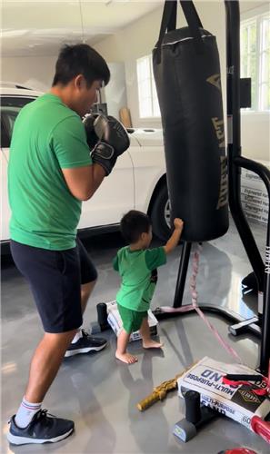 South Korean PGA Tour player An Byeong-hun (L) hits a punching bag as part of his exercise, in this photo provided by An on Sept. 14, 2022. (PHOTO NOT FOR SALE) (Yonhap)