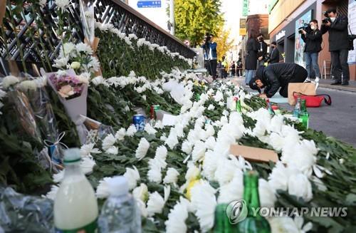 A person is on his knees near Itaewon Station in Seoul on Oct. 31, 2022, in mourning of the deadly Itaewon crowd crush two days ago. (Yonhap)