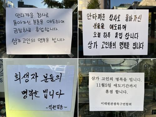 Messages on store fronts in Itaewon on Oct. 31, 2022, express condolences for crowd crush victims and announce temporary closures. (Yonhap)