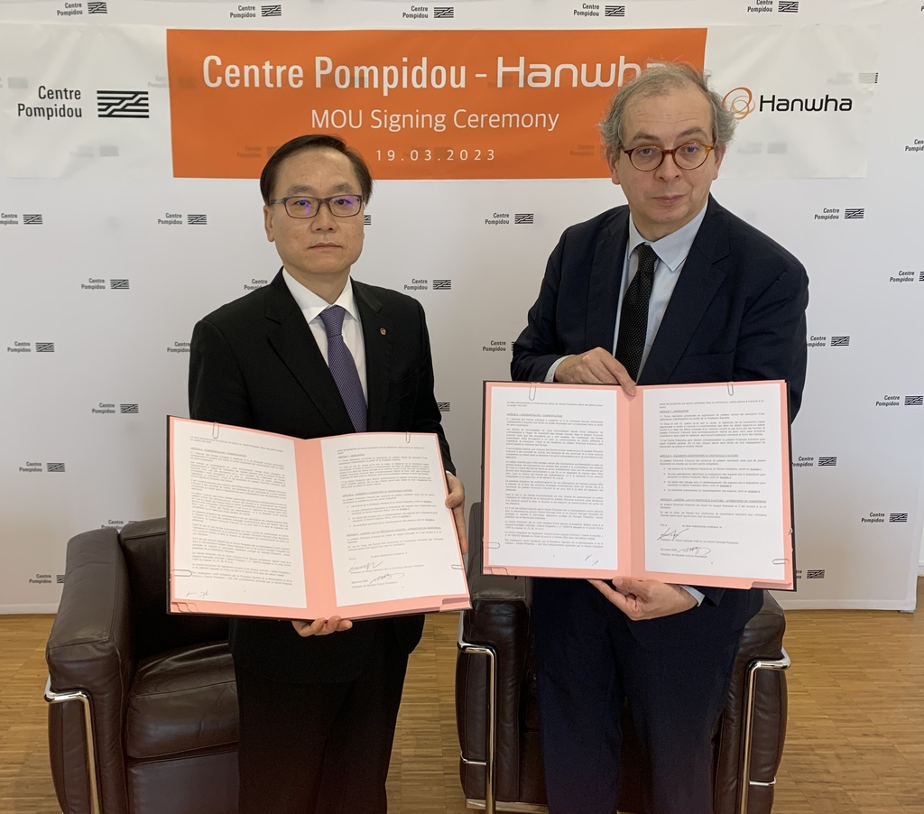 Shin Hyun-woo (L), chief director of the Hanwha Foundation of Culture, and Laurent Le Bon, president of the Centre Pompidou, pose for photo after signing a memorandum of understanding on the partnership for the establishment of a Pompidou museum branch in Seoul and giving Hanwha licensing rights to its brand and properties, during a signing event in Paris on March 19, 2023, in this photo provided by Hanwha. (PHOTO NOT FOR SALE) (Yonhap) 