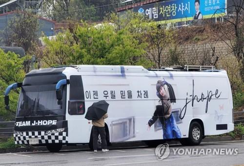 A bus covered with a message of support for BTS member J-Hope and a photo of him, which is believed to be sent by the band's fandom, ARMY, is parked outside an Army boot camp in Wonju, 87 kilometers southeast of Seoul, on April 18, 2023. J-Hope entered the camp to begin his mandatory military service that day. (Yonhap)